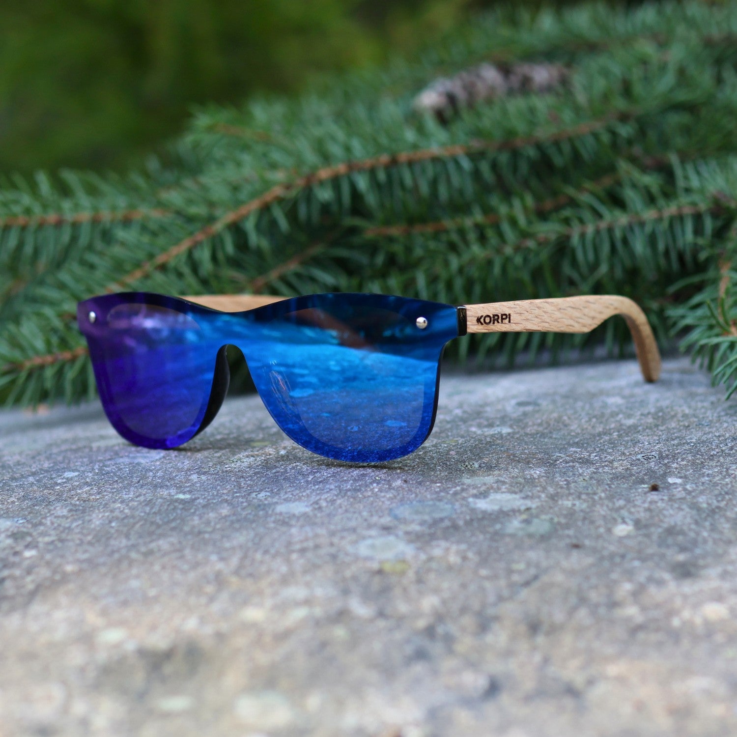 Korpi-aurinkolasit tammipuusangoilla sivulta kuvattuna, korostaen puun luonnollista syykuviota.